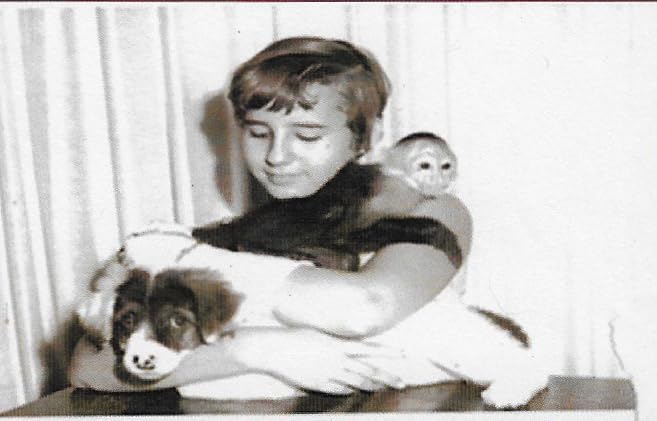 Real black and white photograph of young Nancy Baldwin holding her pet capuchin monkey Linus and a puppy in the Panama Canal Zone, circa 1960s